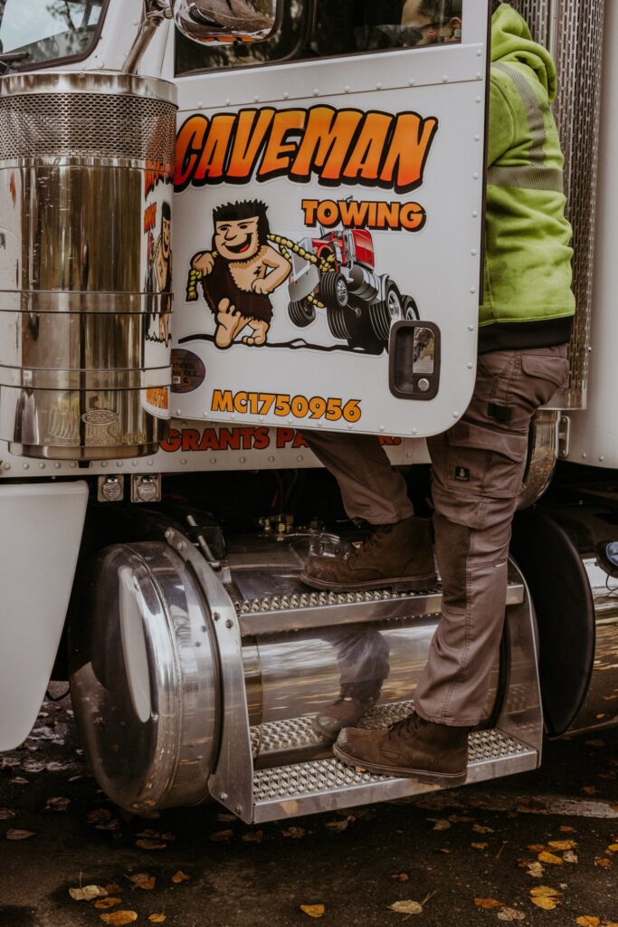 Caveman Towing operator climbing into a heavy wrecker